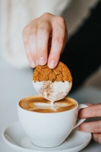 Koekje in de koffie dippen cappuccino